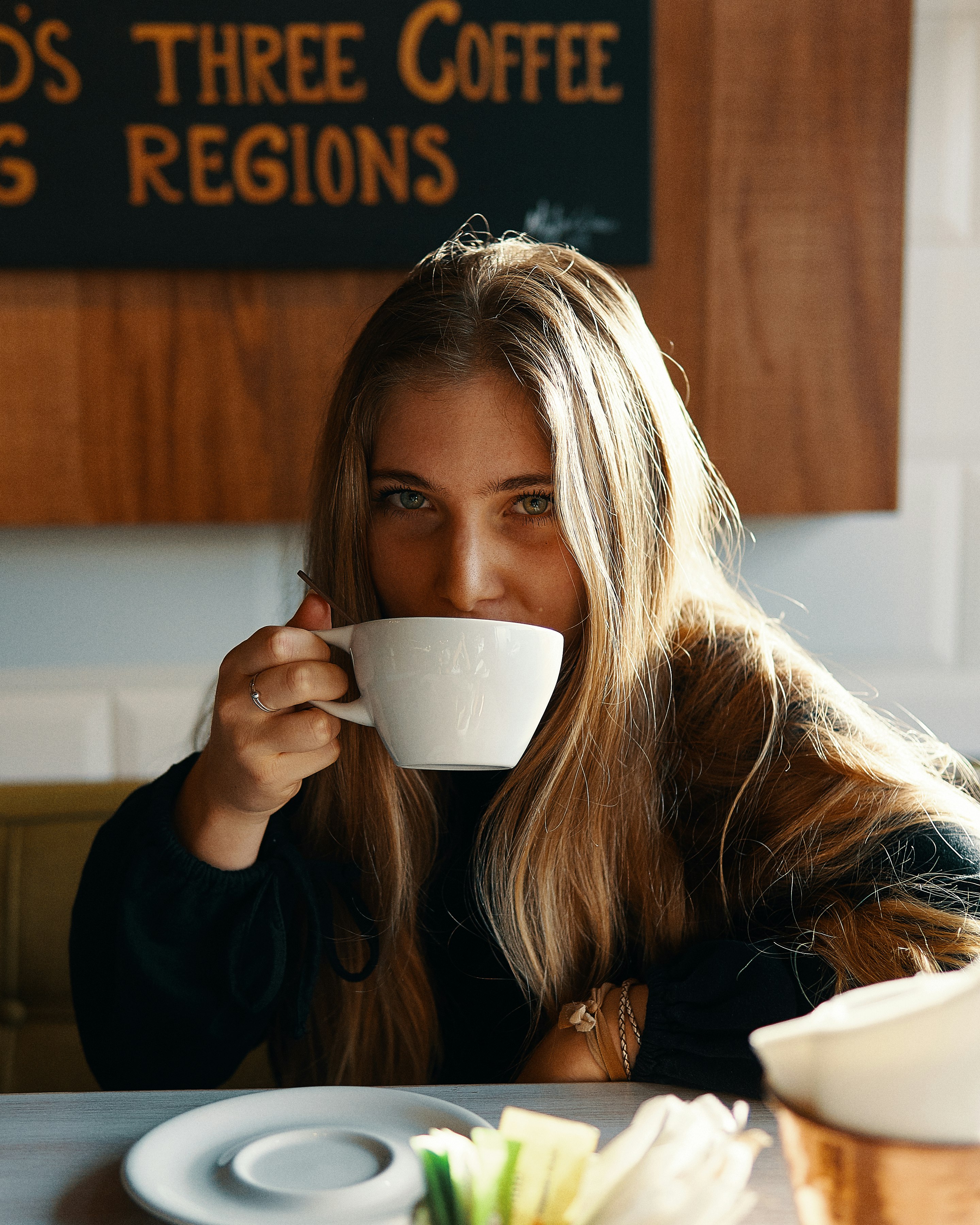 woman holding white ceramic teacup